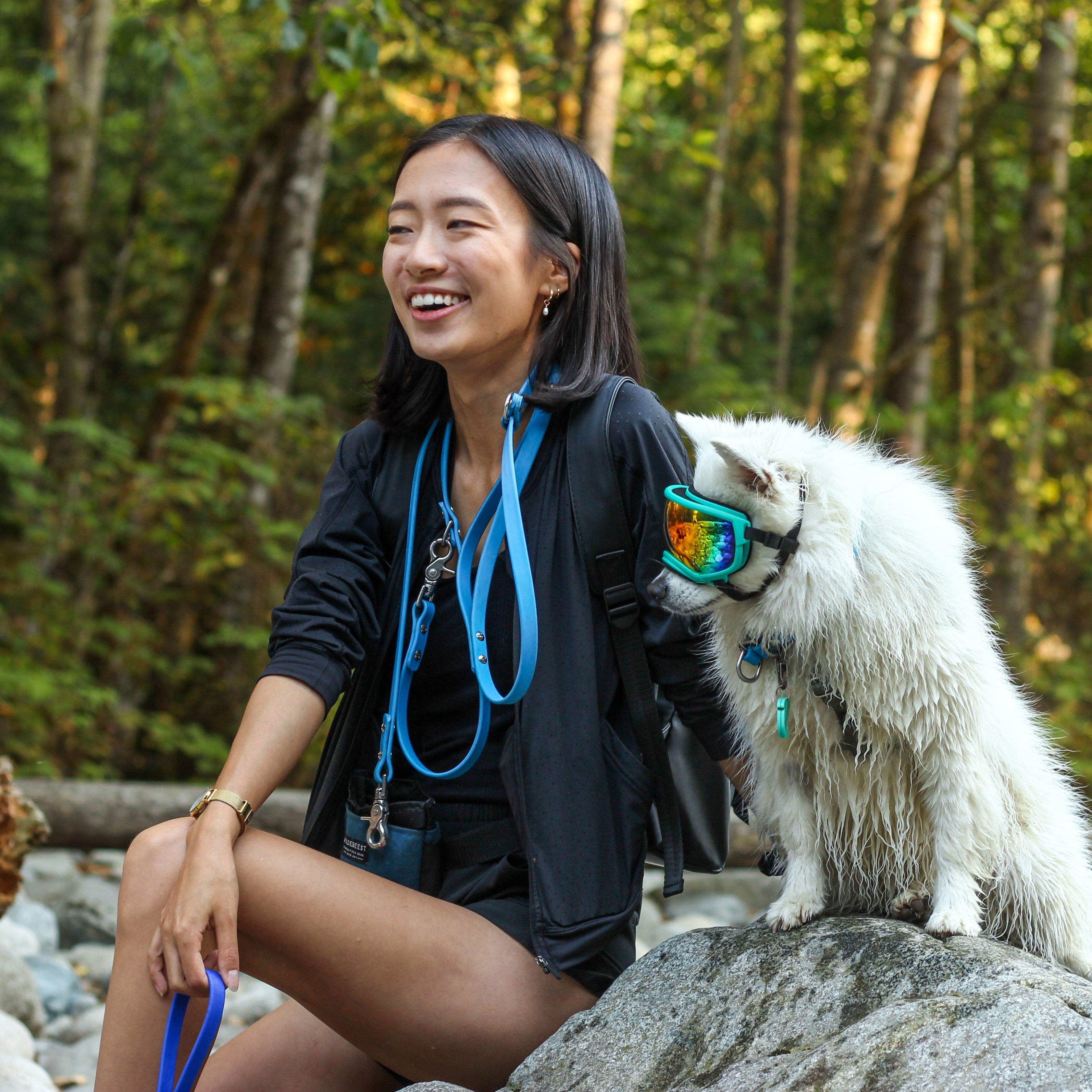 Woman sitting on a rock with her dog with a Blue 6' Hands-Free Waterproof Biothane Dog Leash around her neck