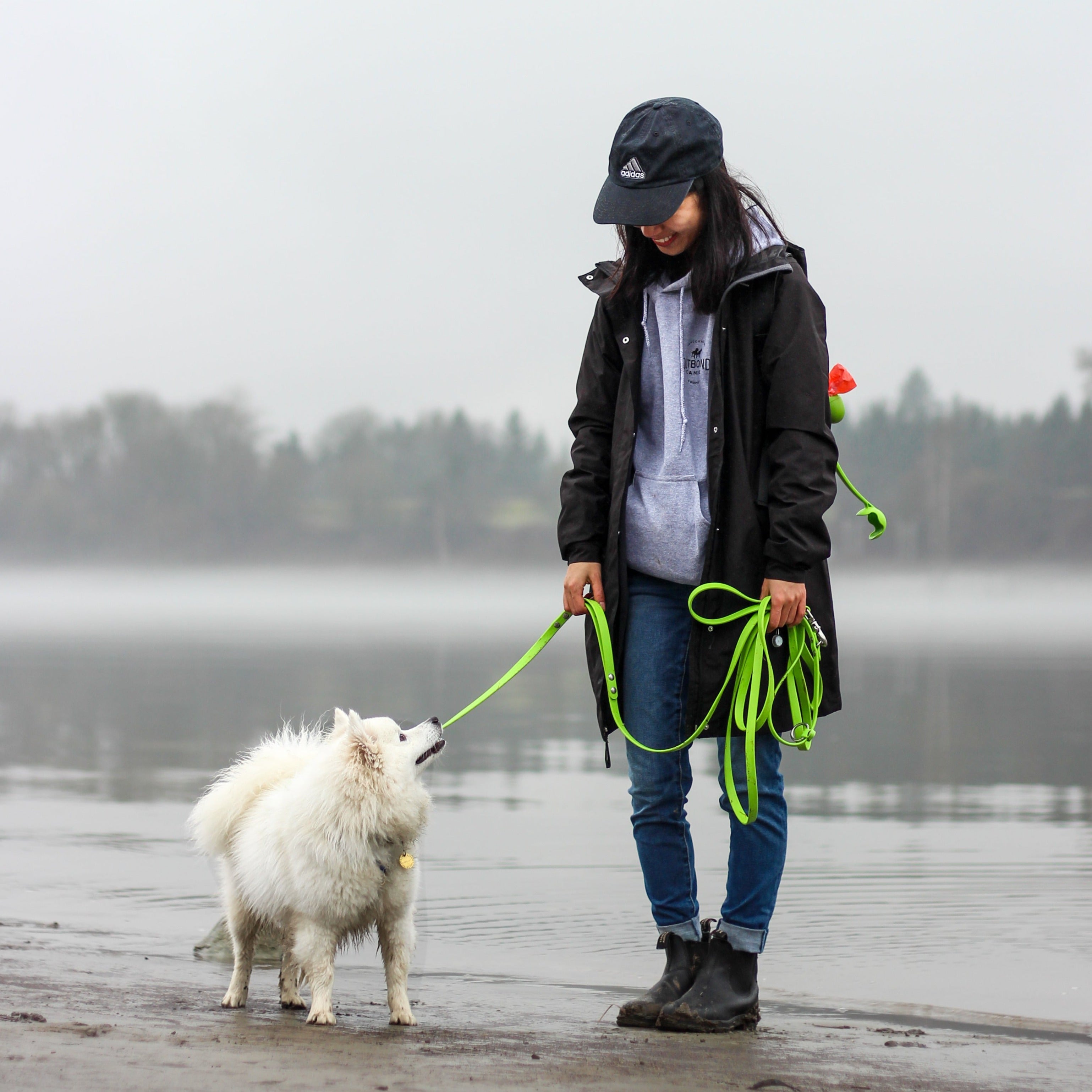 Woman walking her Dog on the Beach using a Green Biothane Hands-Free Long Line